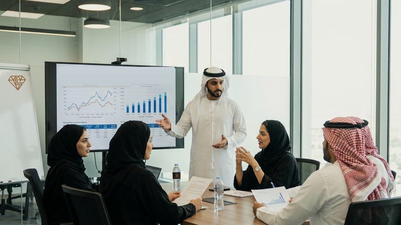فريق Lynvato في قاعة اجتماعات مطلة على أفق المدينة يناقش تحليلًا للسوق معروضًا على الشاشة